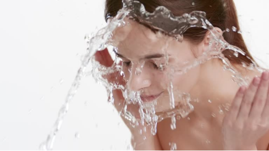 Woman finishes cleansing her face, preparing to use the nose hair trimmer for grooming