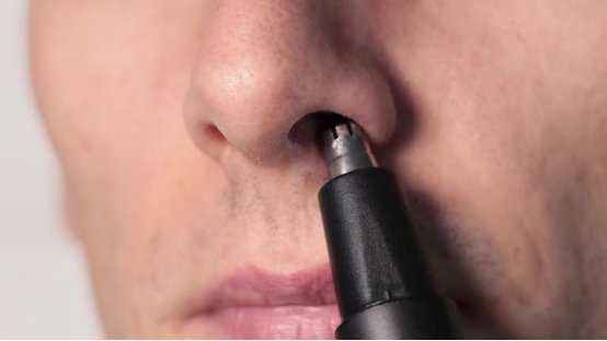 Close-up of a durable electric nose hair trimmer in use, highlighting how a long-lasting model cuts down on frequent replacements to save money over time