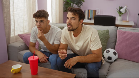 A father and son share a moment on a living room couch, setting the stage for a story about lessons passed through simple tools like a nose hair trimmer.