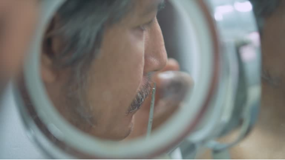Mirror reflection of someone using a nose hair trimmer to groom nasal hair.